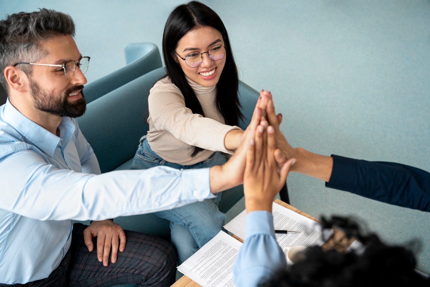 Equipo de personas celebrando con las manos unidas: ética y transparencia en Prosperando